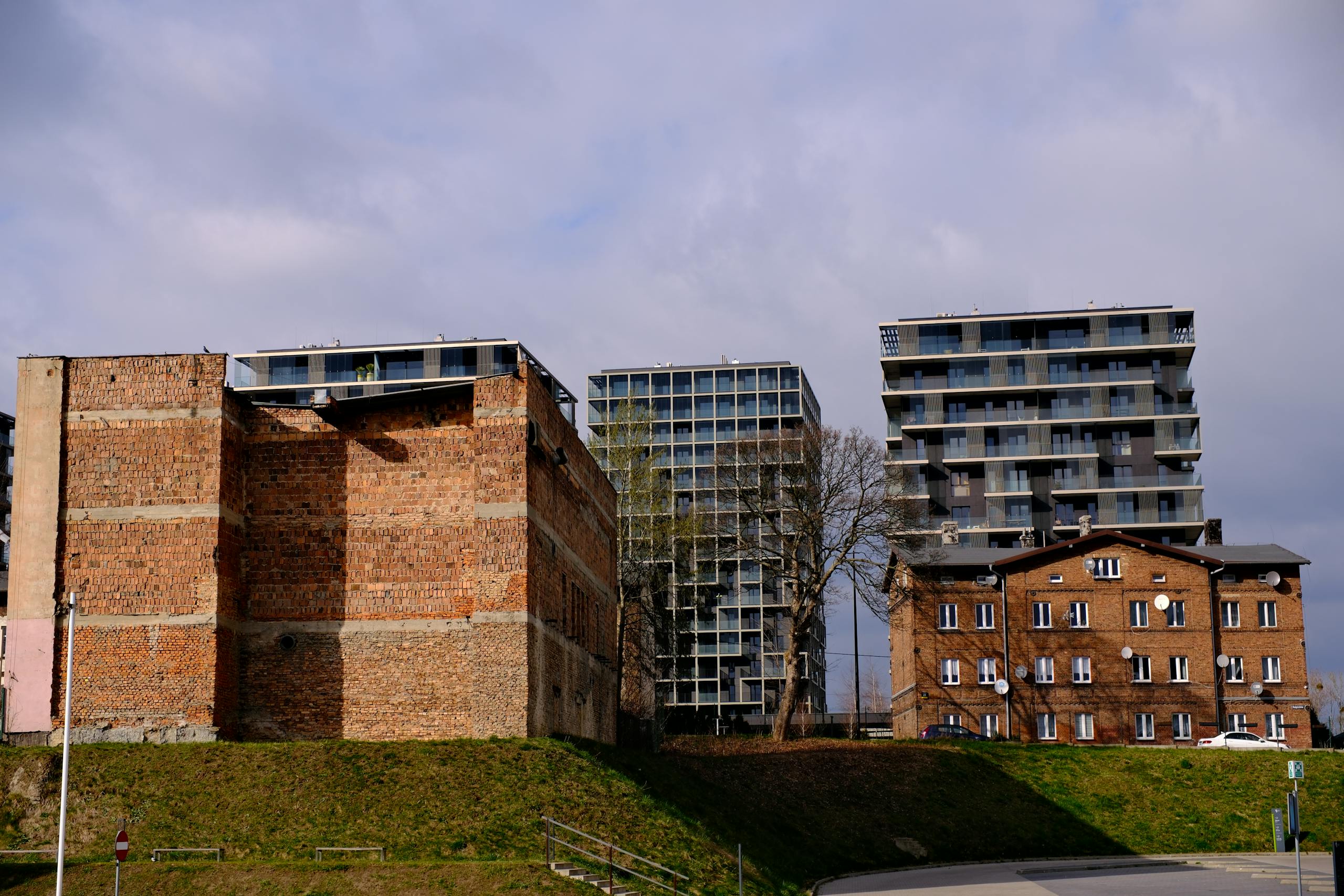 View of modern and traditional brick buildings in Katowice, Poland, showcasing urban contrast.