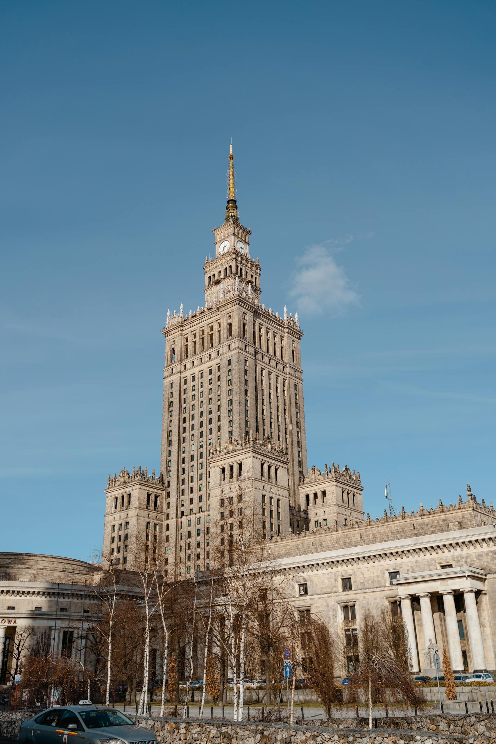 Ikoniczny budynek Pałacu Kultury i Nauki w Warszawie pod jasnym błękitnym niebem w centrum miasta