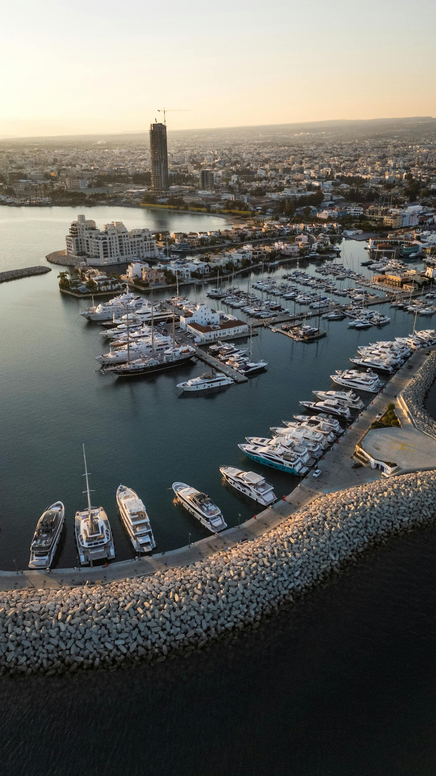 Spektakularny widok z góry na port jachtowy w Limassol na Cyprze z jachtami i panoramą miasta w złotym świetle