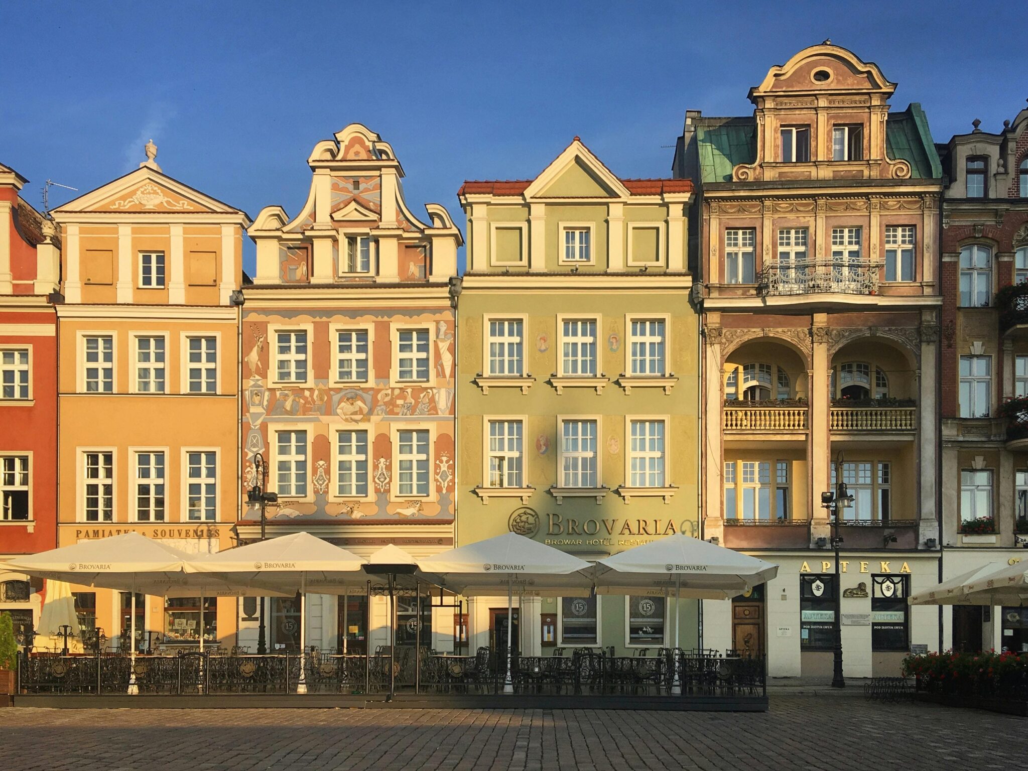 Stary Rynek w Poznaniu z malowniczymi kolorowymi kamienicami. Zabytkowe budynki z kawiarniami i restauracjami - symbol miasta i must-see dla turystów.
