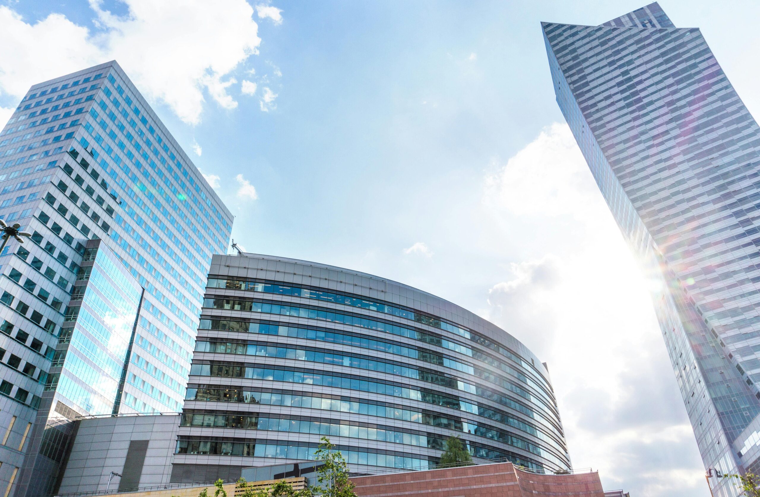 Widok na nowoczesne budynki biznesowe w Warszawie z charakterystycznymi szklanymi fasadami. Centrum finansowe stolicy Polski z imponującymi wieżowcami i współczesną architekturą.