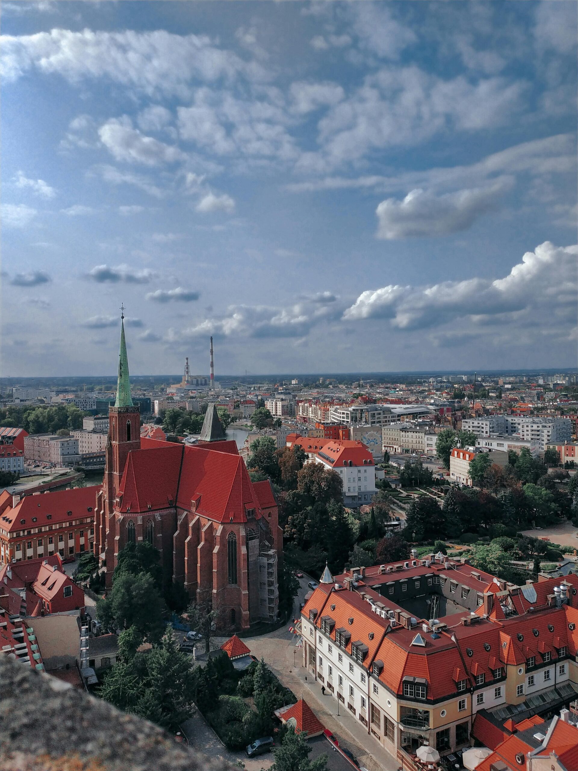 Wspaniały widok z lotu ptaka na Wrocław z gotycką katedrą i czerwonymi dachami Starego Miasta. Panorama centrum Wrocławia z charakterystyczną architekturą, zielenią miejską i dramatycznym niebem.