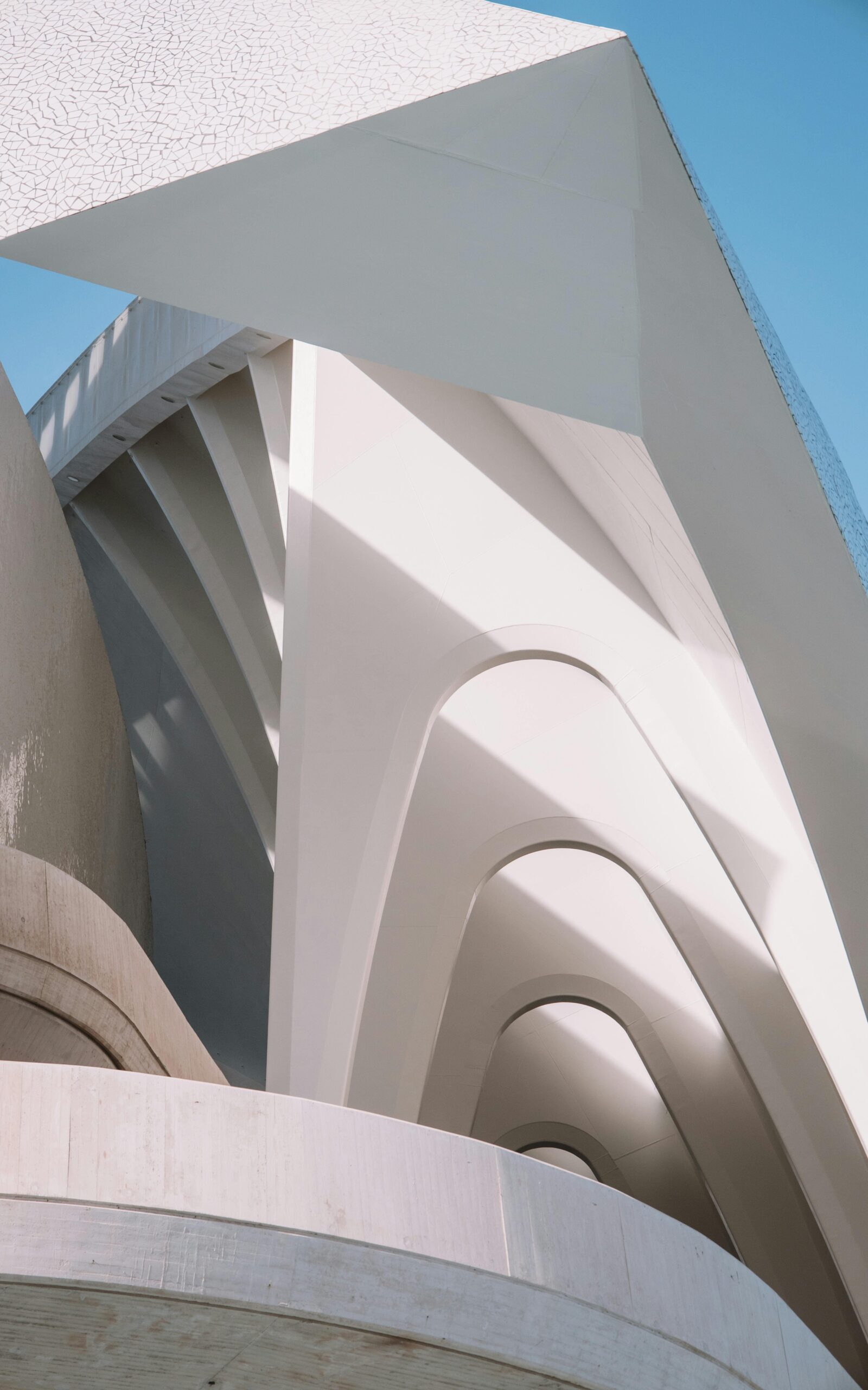 Nowoczesna architektura minimalistyczna - białe betonowe łuki i geometryczne formy fasady, architektura brutalistyczna z powtarzającymi się elementami architektonicznymi