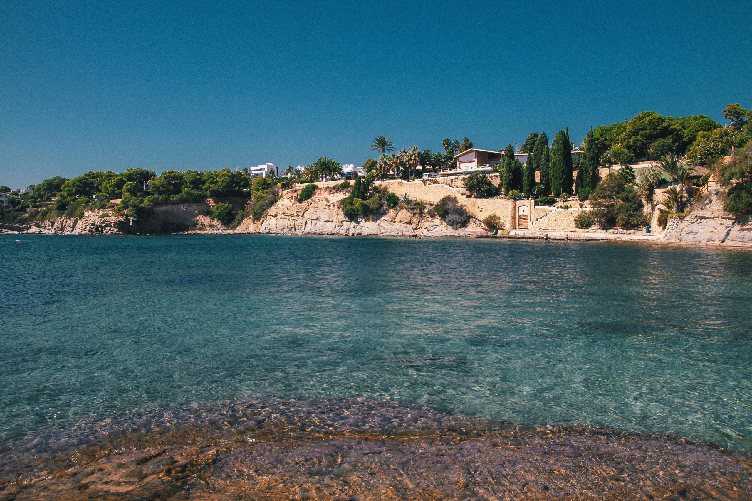 Hiszpania wybrzeże krystaliczna woda Costa Brava - wille na klifach z widokiem na morze, turkusowe wody Morza Śródziemnego, luksusowe nieruchomości nad zatoką z palmami i sosnami