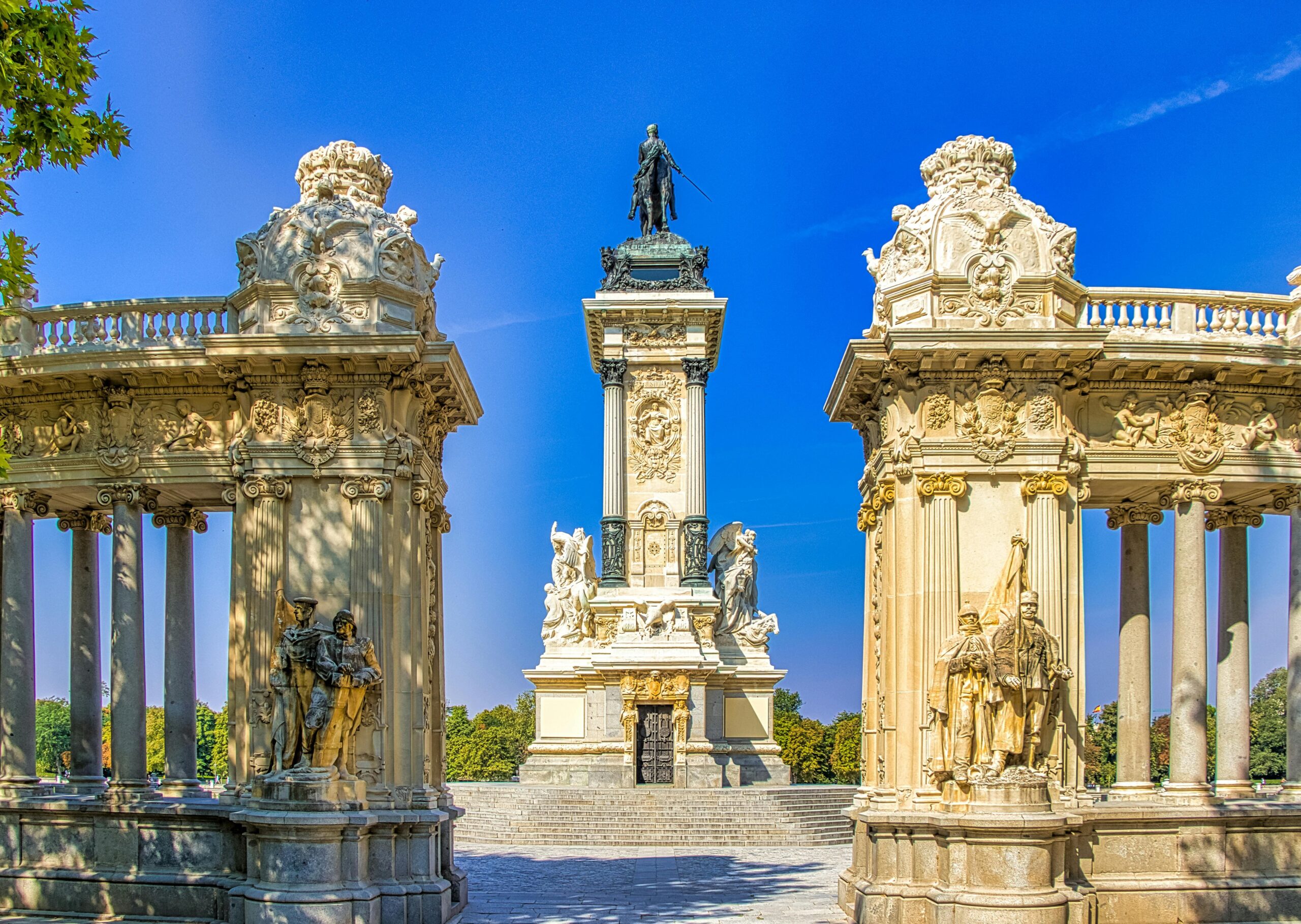 Madryt Parque del Retiro pomnik Alfonso XII - kolumnada koryncka z rzeźbami i centralną kolumną, klasyczna architektura hiszpańska w parku, monumentalny komplekс przy Estanque del Retiro