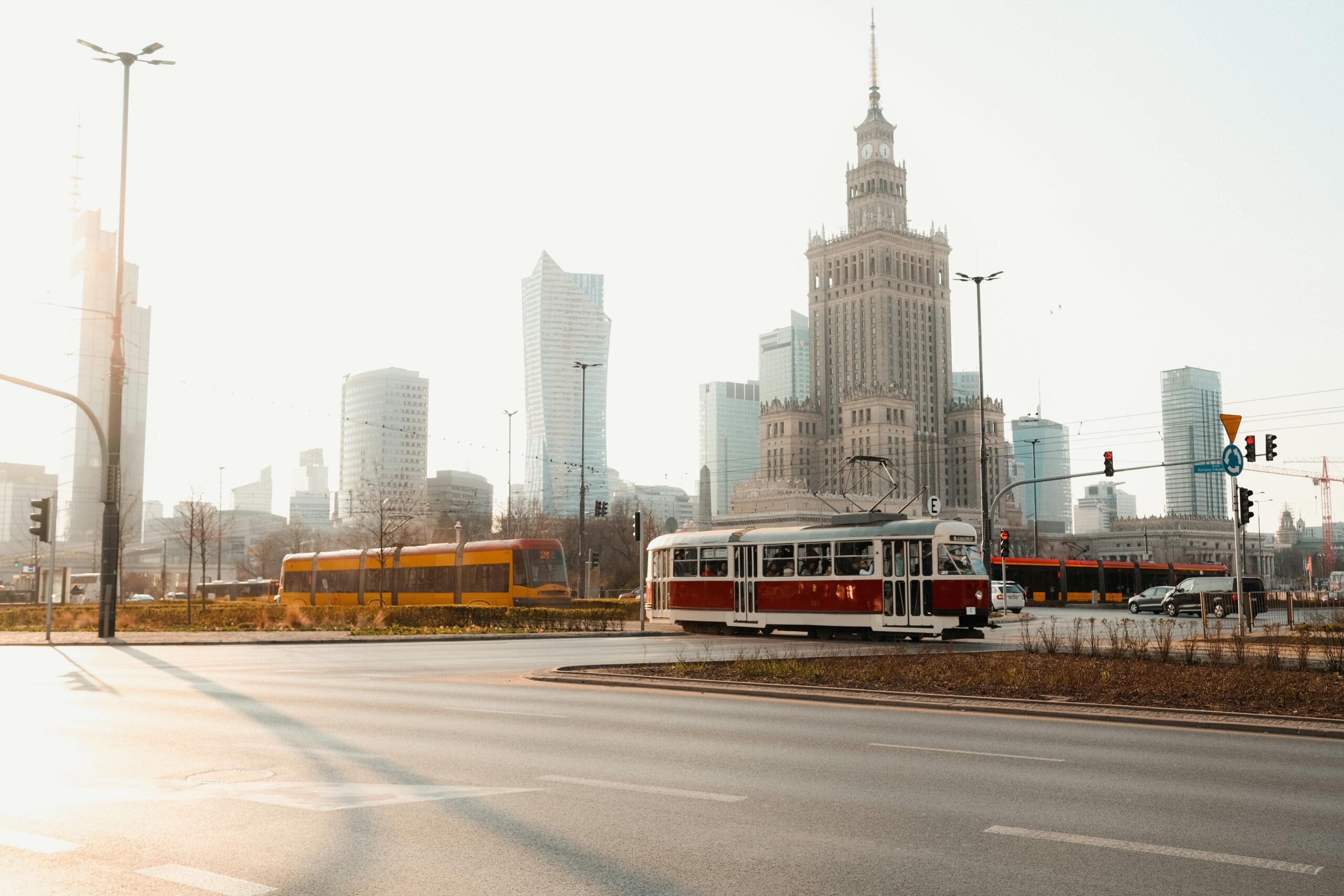 Zabytkowy tramwaj na tle Pałacu Kultury i Nauki oraz nowoczesnego skyline Warszawy o wschodzie słońca, Polska